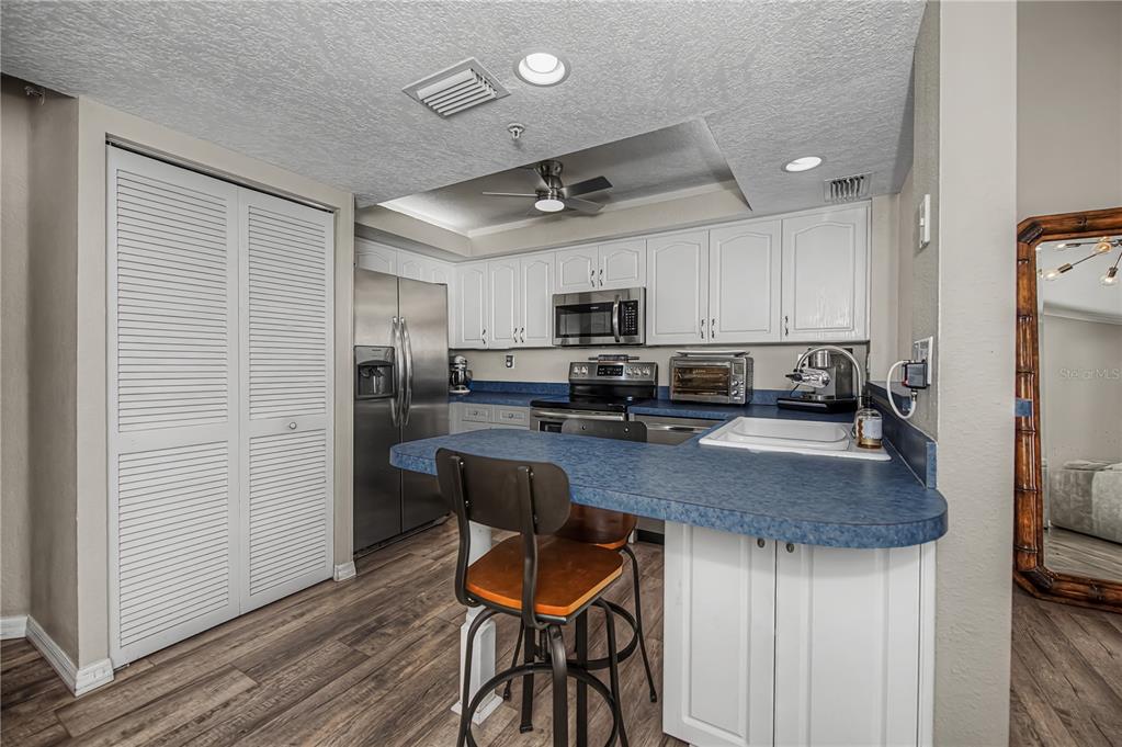 2255 North Beach Road, Unit 20 Englewood, FL 34223 - Photo 19 of 50 a kitchen with stainless steel appliances granite countertop a table chairs refrigerator and microwave