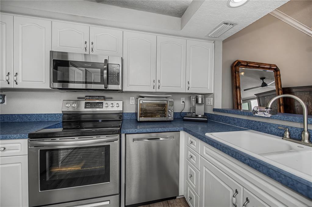 2255 North Beach Road, Unit 20 Englewood, FL 34223 - Photo 21 of 50 a kitchen with granite countertop white cabinets and stainless steel appliances