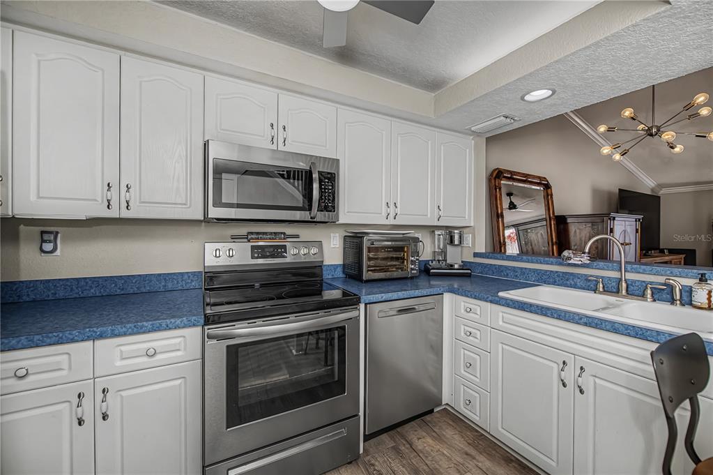 2255 North Beach Road, Unit 20 Englewood, FL 34223 - Photo 22 of 50 a kitchen with cabinets stainless steel appliances a sink and a microwave