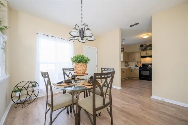 a view of a dining room with furniture wooden floor and chandelier