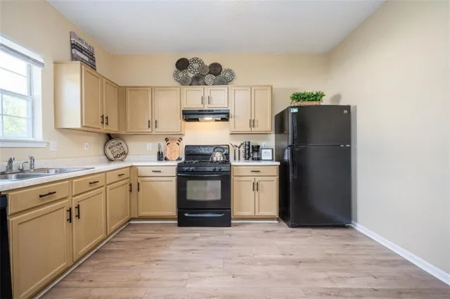 a kitchen with a refrigerator sink and cabinets