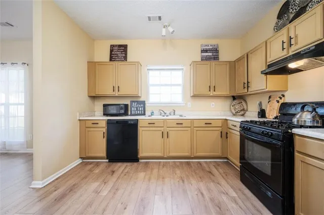 a kitchen with a sink stove top oven and cabinets