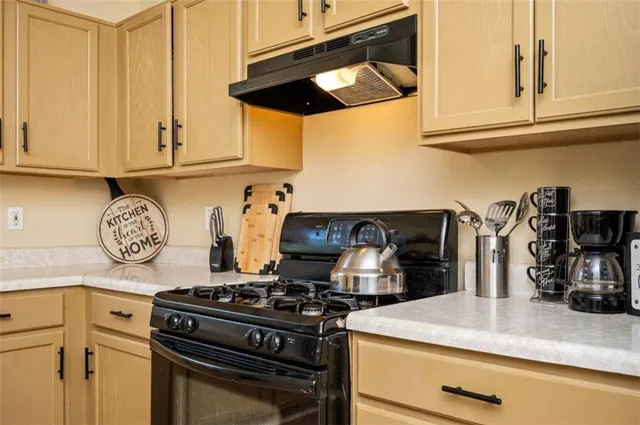 a kitchen with granite countertop a stove and a sink