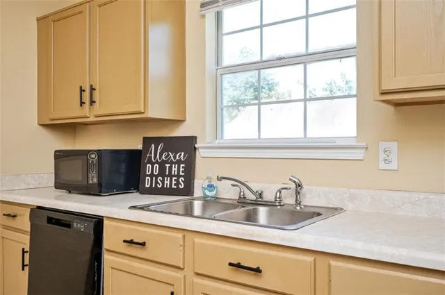 a kitchen with stainless steel appliances granite countertop a sink and a white cabinets