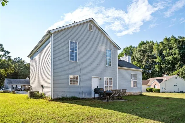 a backyard of a house with table and chairs