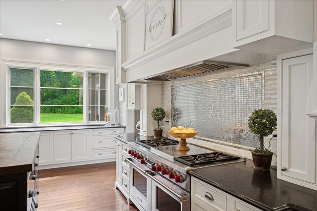 a kitchen with a stove and a wooden floor