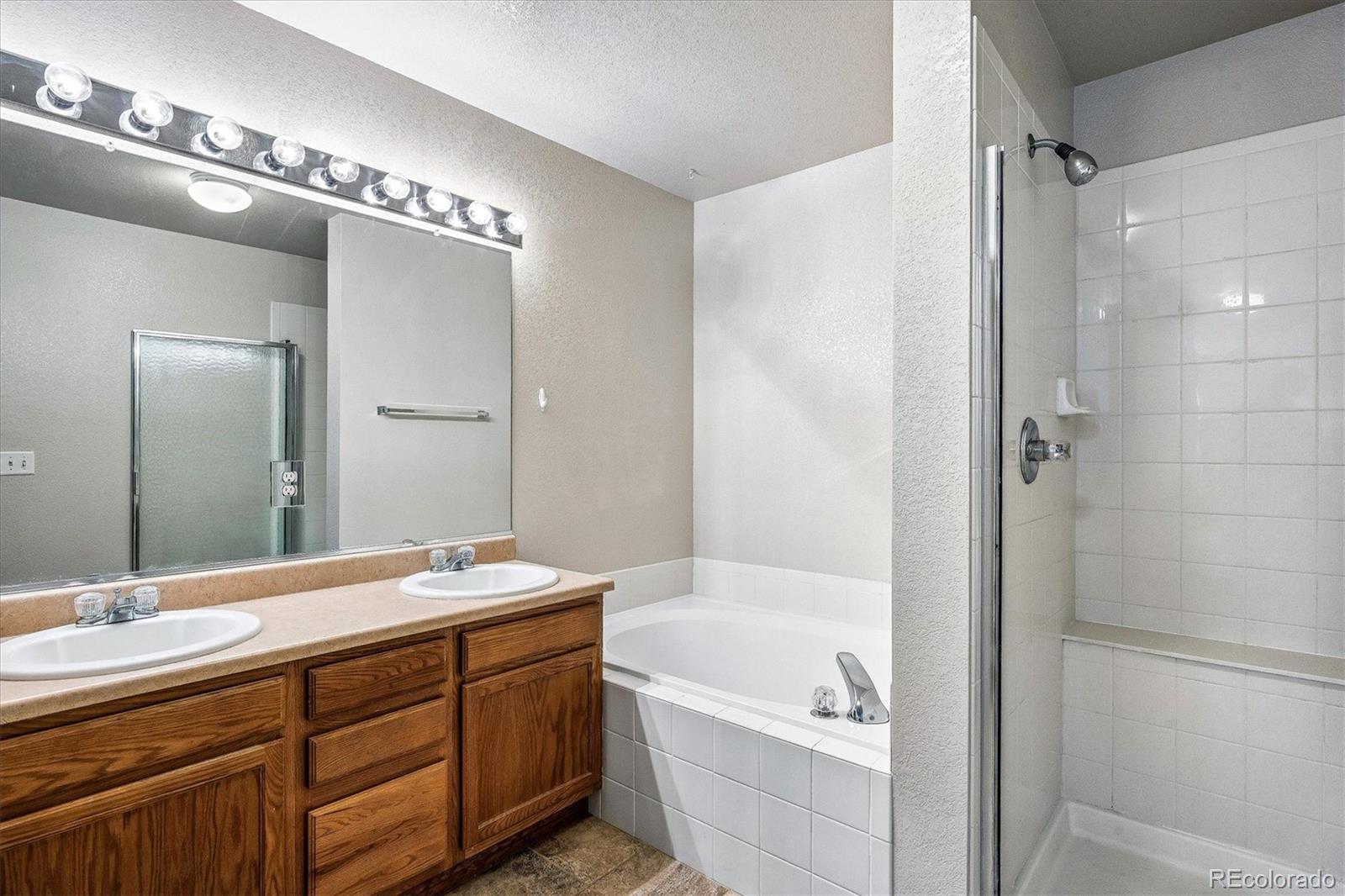 4545 South Taft Way Morrison, CO 80465 - Photo 20 of 24 a bathroom with a tub a double vanity sink and mirror