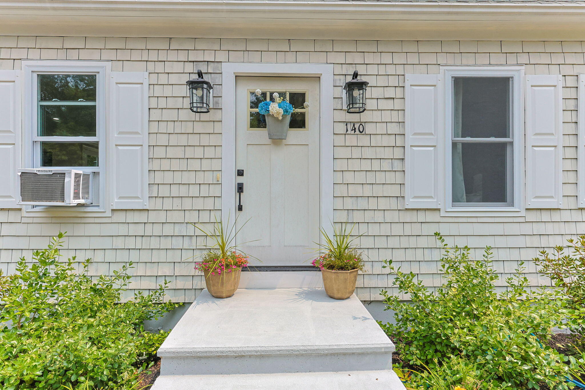 140 Noisy Hole Road Mashpee, MA 02649 - Photo 4 of 53 a view of a door of the house with potted plants