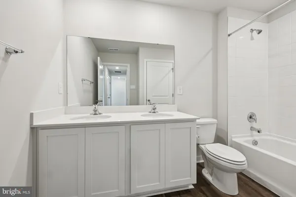 a bathroom with a toilet a sink a mirror and a bathtub