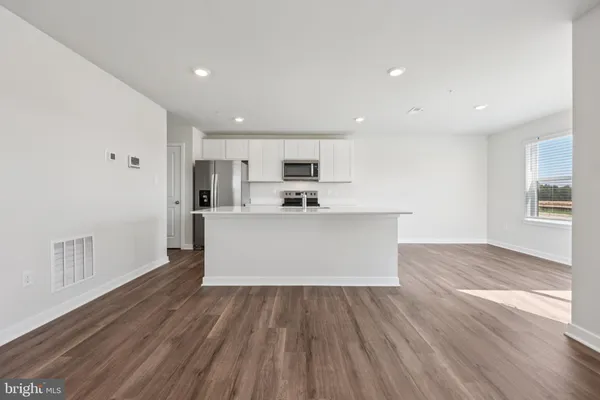 a view of kitchen with wooden floor and electronic appliances