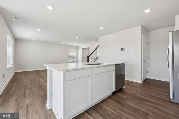 a kitchen with kitchen island a sink and wooden floor