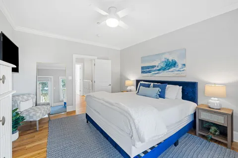 a bedroom with a bed and a flat tv screen on dresser