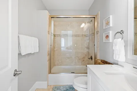 a bathroom with a sink a toilet and shower