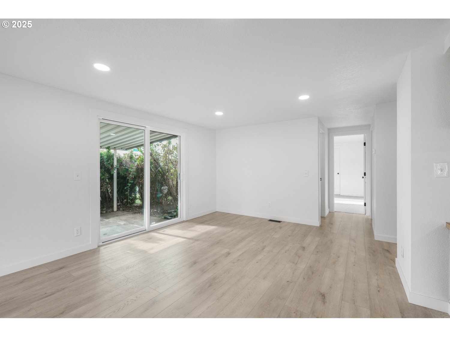 871 Liberty Bell Drive, Unit 474 Beaverton, OR 97006 - Photo 5 of 26 a view of an empty room with wooden floor and a window