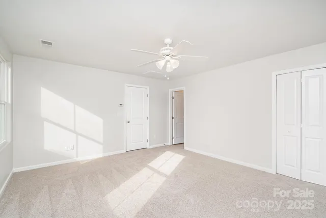 a view of a big room with a ceiling fan and chandelier fan
