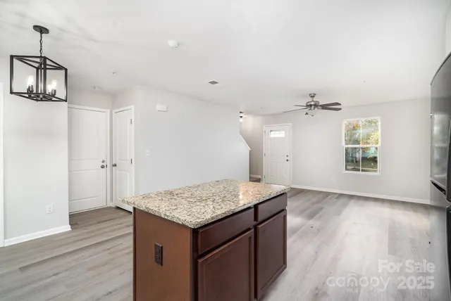 an empty room with wooden floor and ceiling fan