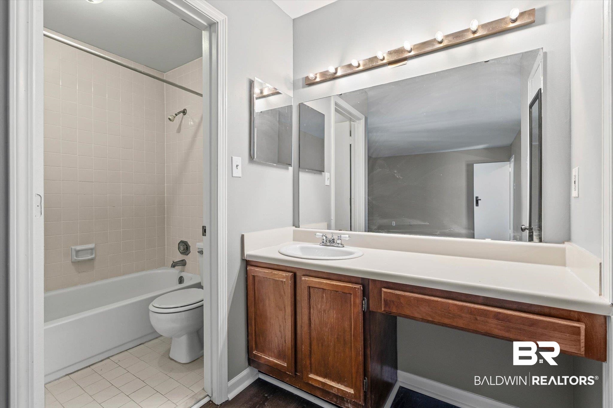 6701 Dickens Ferry Road, Unit 100 Mobile, AL 36608 - Photo 16 of 24 Bathroom featuring vanity, shower / tub combination, and dark tile patterned floors