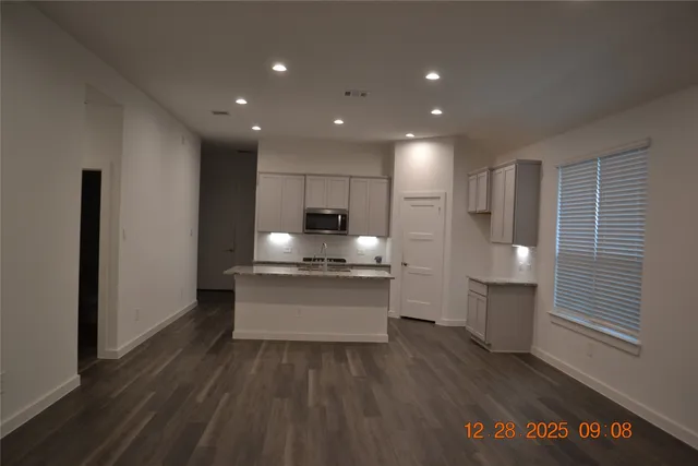 a kitchen with kitchen island a sink stainless steel appliances and cabinets