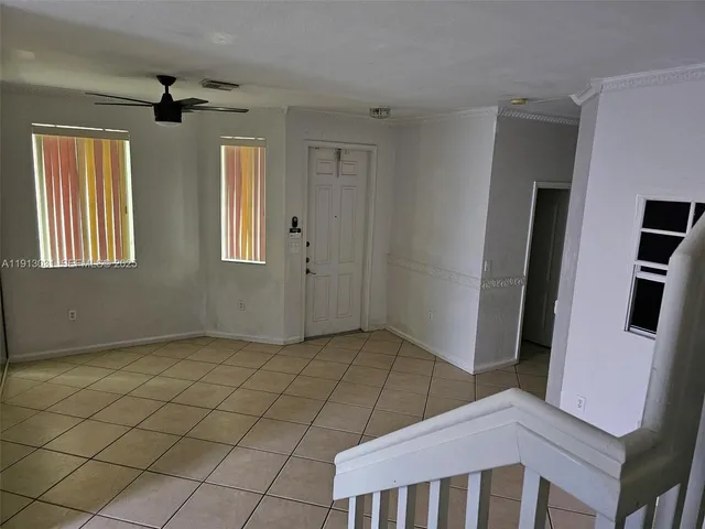 a view of an empty room with windows and closet