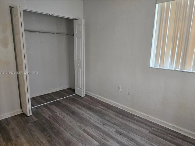 an empty room with wooden floor and a window
