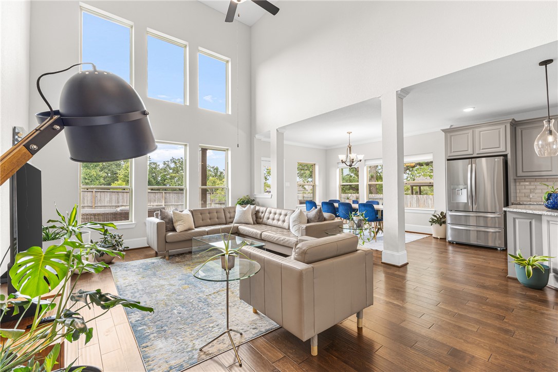 3632 Haskell Hollow Loop College Station, TX 77845 - Photo 14 of 42 Living area with a high ceiling, a chandelier, dark wood finished floors, and a ceiling fan