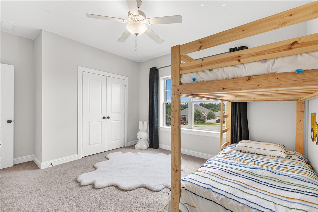 3632 Haskell Hollow Loop College Station, TX 77845 - Photo 32 of 42 a bedroom with a bed and a large mirror with a flat tv screen