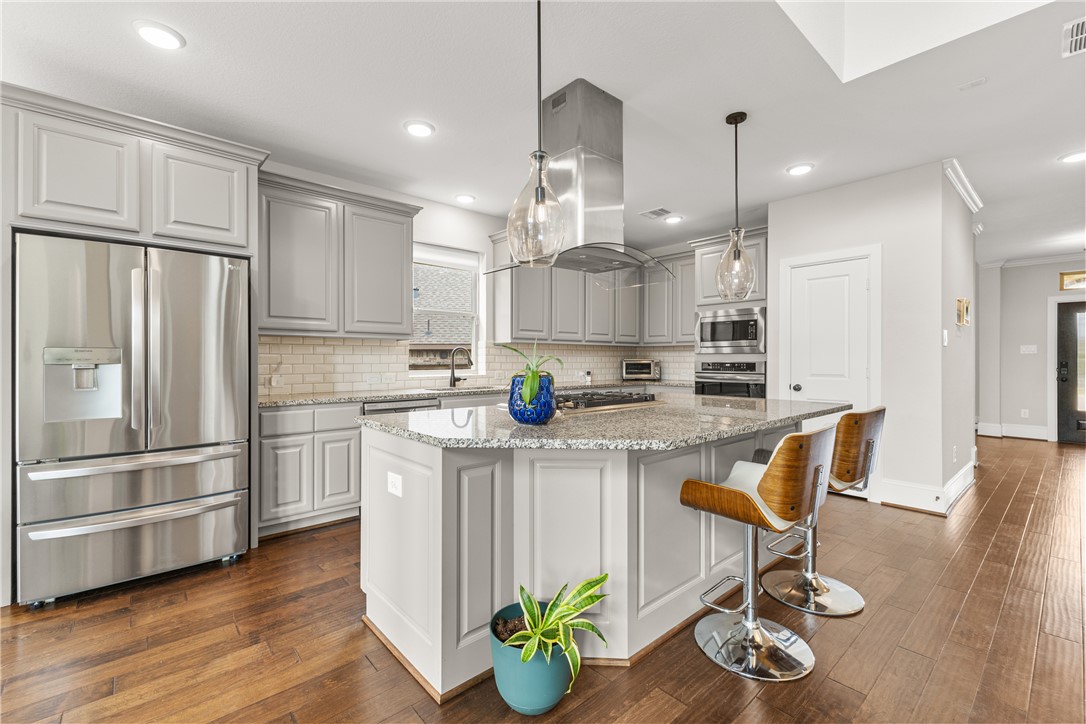 3632 Haskell Hollow Loop College Station, TX 77845 - Photo 9 of 42 a kitchen with stainless steel appliances granite countertop a refrigerator a sink dishwasher a stove and white cabinets with wooden floor