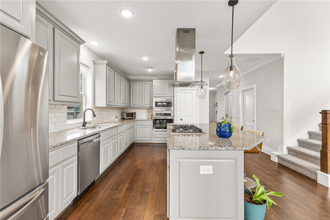 3632 Haskell Hollow Loop College Station, TX 77845 - Photo 10 of 42 a large kitchen with stainless steel appliances a refrigerator a sink dishwasher a oven a dining table and chairs with wooden floor