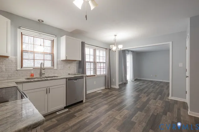 a large kitchen with cabinets wooden floor and stainless steel appliances