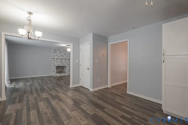 an empty room with wooden floor mirror and windows