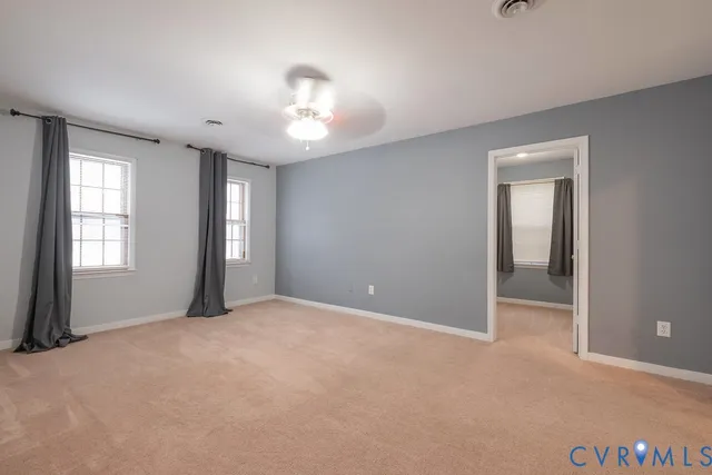 an empty room with windows and closet