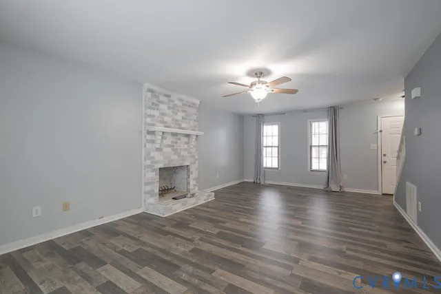a view of an empty room with a window and a kitchen