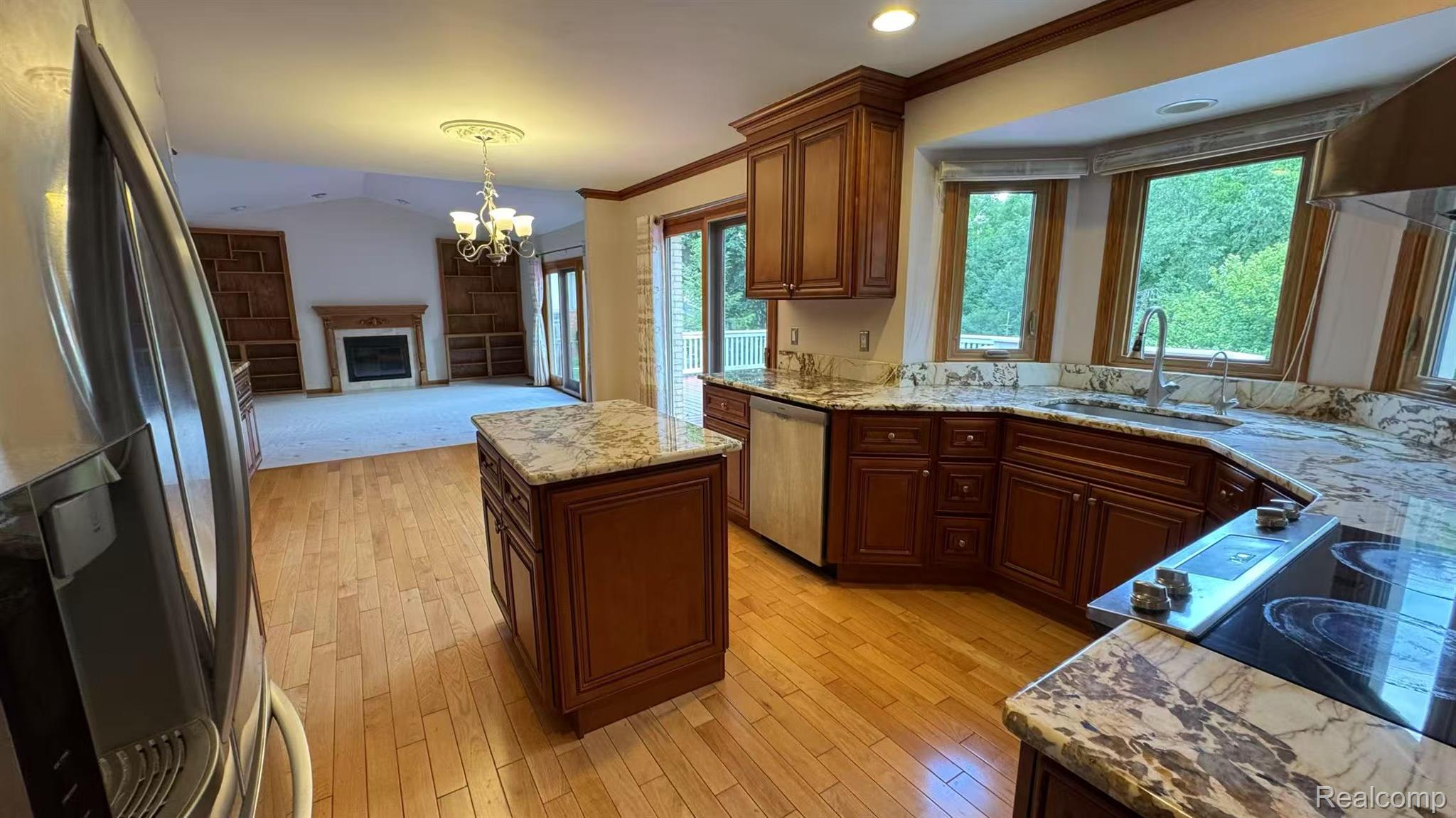 3440 Salem Drive Rochester, MI 48306 - Photo 13 of 33 Kitchen featuring wood-finish flooring, a central island with a stone countertop, a built-in electric cooktop, and wooden cabinetry