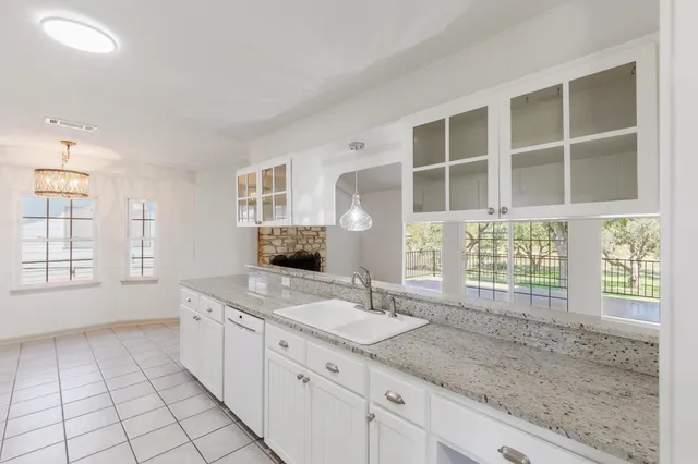 a bathroom with a granite countertop sink mirror and next to a window