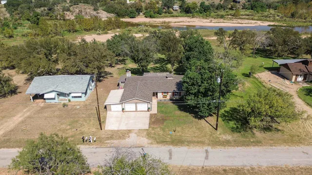 an aerial view of residential houses with outdoor space and trees