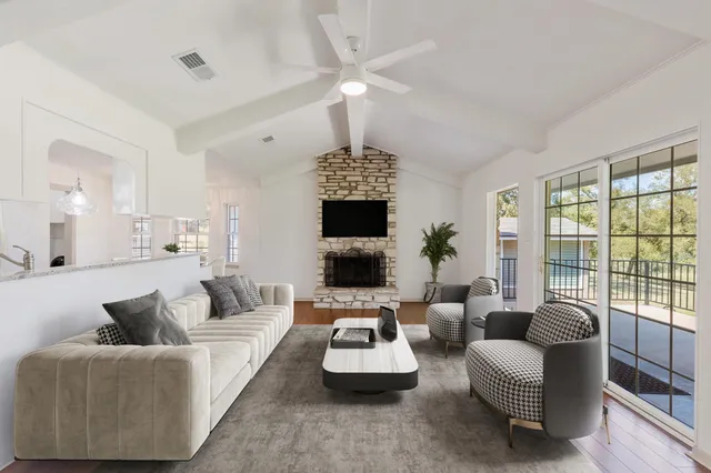a living room with furniture a flat screen tv and a large window