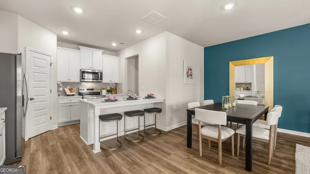 a kitchen with kitchen island a appliances dining table and chairs