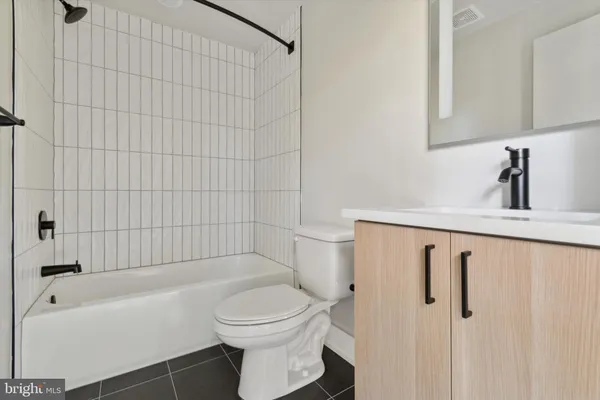 a bathroom with a toilet a sink a mirror and bathtub