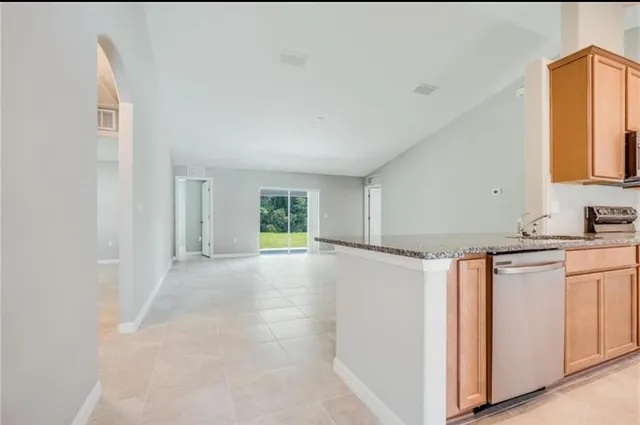 a view of a kitchen with granite countertop cabinets and a refrigerator