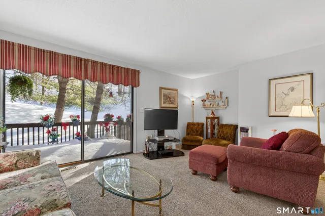a living room with furniture a flat screen tv and a large window