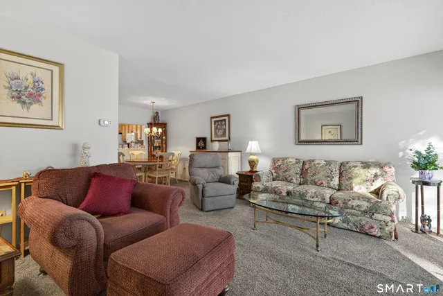 a living room with furniture a couch and paintings on the wall