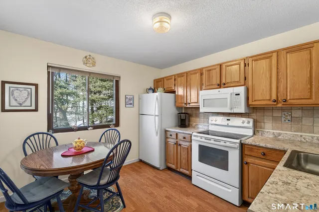 a kitchen that has a stove a table and chairs in it
