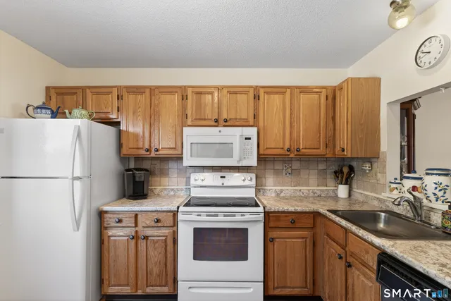 a kitchen with a refrigerator stove top oven and sink