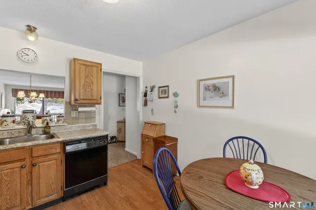 a kitchen with stainless steel appliances granite countertop a stove a sink a dining table and chairs
