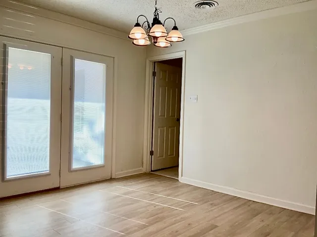 a view of an empty room with a chandelier