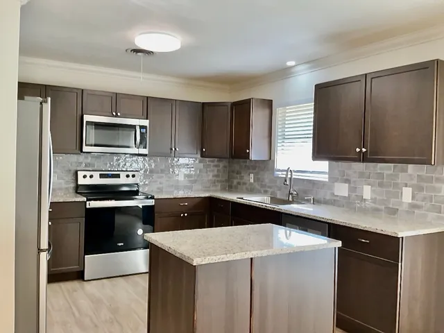 a kitchen with stainless steel appliances a stove sink microwave and cabinets