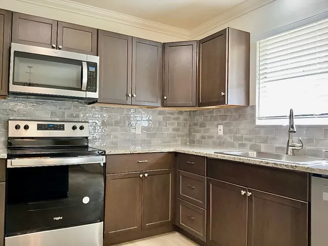a kitchen with a sink stove and microwave