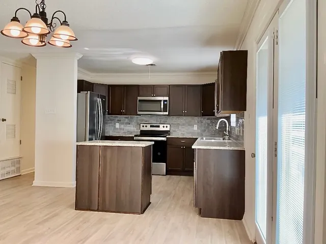 a kitchen with stainless steel appliances granite countertop a refrigerator and a stove top oven