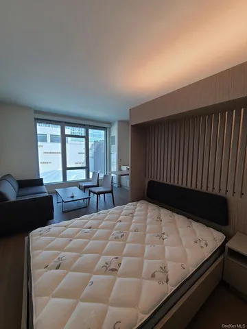 a bed sitting in a bedroom next to a window with two lamp