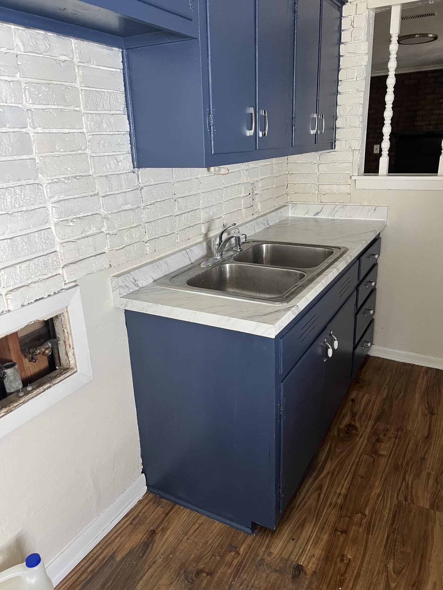 518 Harris Street Collierville, TN 38017 - Photo 12 of 13 Kitchenette featuring a double stainless steel sink, wood-finish flooring, and blue cabinetry with brushed nickel hardware